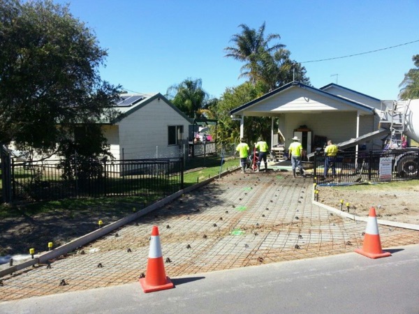 A driveway prepared with steel mesh while the crew works beside a concrete truck
