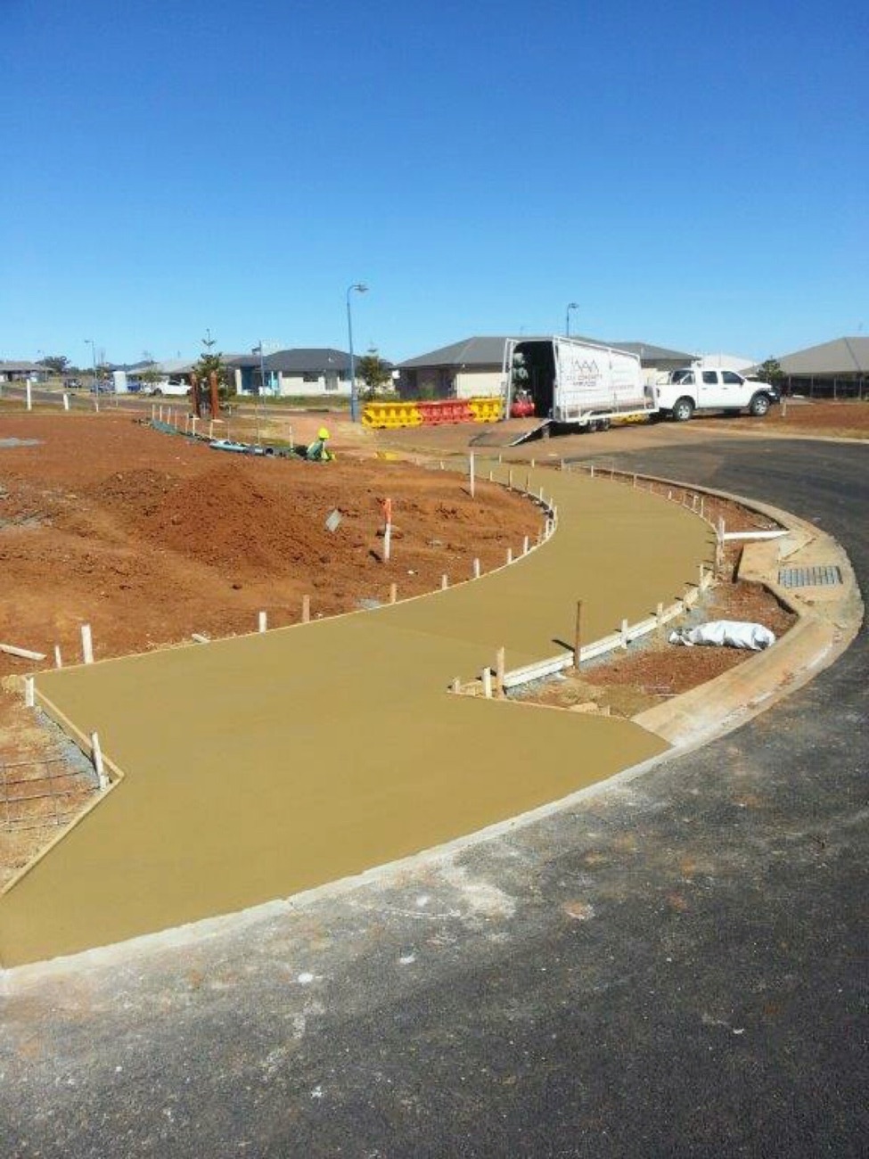 Wet coloured concrete forming a curved path in a new estate